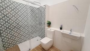 a bathroom with a toilet and a sink and a shower at Mi Casita De Garraf in Garraf