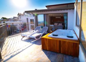 a jacuzzi tub on a balcony with chairs at Noel Baba Hotel in Kas