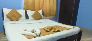 a bed with a white animal laying on it at Calangute Inn in Calangute