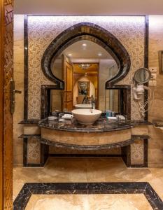 Helnan Landmark Hotel في القاهرة: حمام مع حوض ومرآة كبيرة