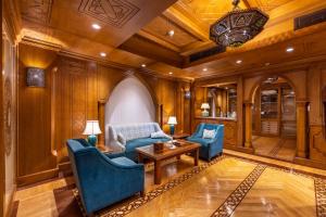 Helnan Landmark Hotel في القاهرة: غرفة معيشة مع كراسي زرقاء وطاولة