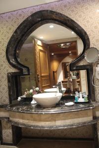 a bathroom with a sink and a large mirror at Helnan Landmark Hotel in Cairo