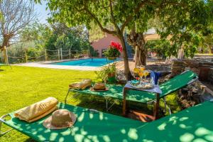 uma mesa de piquenique com chapéus ao lado de uma piscina em Villa Oliva Ecofriendly em Aci Catena