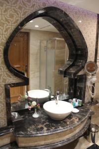uma casa de banho com um lavatório e um espelho grande em Helnan Landmark Hotel em Cairo