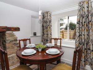 a dining room with a table and chairs and a window at Cob Cottage in Newton Abbot