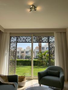 a living room with a large window and a couch at Mangroovy Residence El Gouna - Grovin in Hurghada