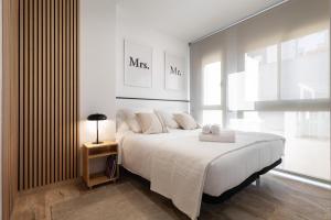 una camera da letto con un grande letto con due asciugamani di Cozy Apartment Les Corts a Barcellona