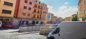 una furgoneta estacionada en una calle de la ciudad con edificios en Hostal segovia adults only en Segovia