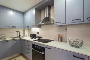 a kitchen with white cabinets and a sink at Cozy Apartment Les Corts in Barcelona