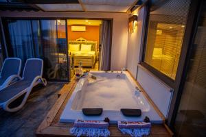 a large bath tub in a room with a bedroom at Noel Baba Hotel in Kas