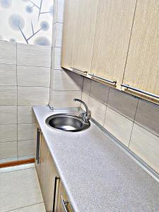a small kitchen with a sink and wooden cabinets at Посуточно квартира в Алматы 1 in Almaty +6 photos