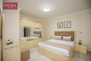 Habitación de hotel con cama grande y espejo en Prime Select Kattameya One, en El Cairo