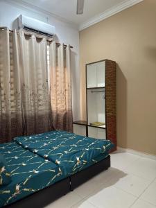 a bedroom with a bed and a window with curtains at Zuriana Ashraf Homestay Kota Bharu in Kota Bharu