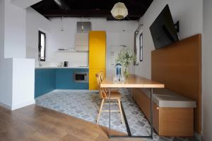 cocina con mesa y pared amarilla y blanca en numa I Vega Apartments, en Granada