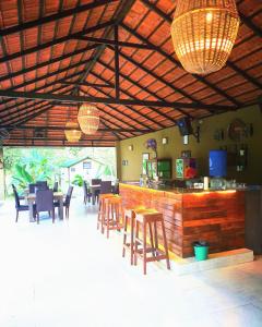 a restaurant with a bar with wooden tables and chairs at The Road's End in Gonikoppal