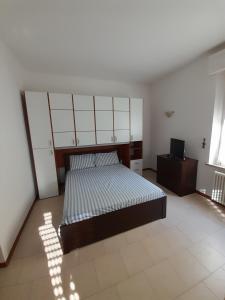 1 dormitorio con 1 cama y TV en Breve Ristoro, en Parma