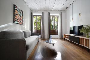 sala de estar con sofá y TV en numa I Vega Apartments, en Granada