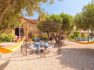 a swing set with a table and chairs in a park at LES FLAMANTS in Portiragnes