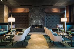 a lobby with tables and chairs and a fireplace at Van der Valk Hotel Enschede in Enschede