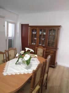 uma mesa de jantar com um vaso de flores em Apartment Lile em Kuciste