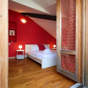 una camera con un letto bianco su una parete rossa di Moscova Charme Apartment a Milano