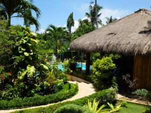a resort with a thatch roof and a swimming pool at Palmhill Villa in Boracay