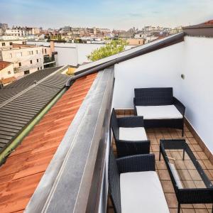 een balkon met 2 banken en uitzicht op de stad bij Moscova Charme Apartment in Milaan