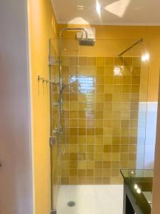 ein Bad mit einer Dusche und gelben Fliesen in der Unterkunft B&B NR6 in Herbaijum