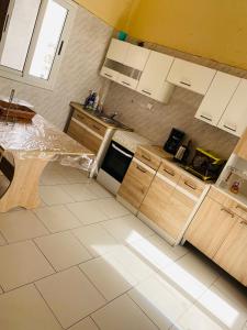 a kitchen with wooden cabinets and a counter top at Idéal et meilleur Appart du coin Guediawaye in Pikini Bougou