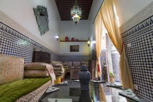 a living room with a couch and a table at Riad Sanaa Rose in Fez