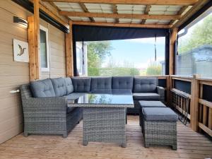 a patio with a couch and a table and chairs at Prachtig chalet OK50 D12 op familiecamping in Oostkapelle