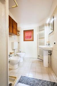 bagno con due servizi igienici, lavandino e finestra di Moscova Charme Apartment a Milano