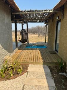 eine Veranda mit einer Hängematte, die von einem Haus hängt in der Unterkunft LookOut Safari Lodge in Klipdrift