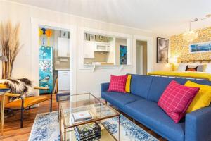 uma sala de estar com um sofá azul com almofadas vermelhas e amarelas em Sutro: Vibrant & Cozy Studio in Central Noe Valley em São Francisco