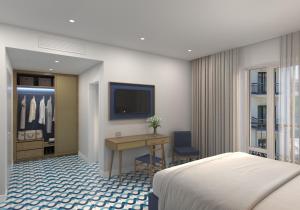 索倫托的住宿－弗洛拉大酒店，酒店客房配有一张床、一张书桌和一台电视。