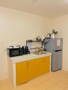 a kitchen with a sink and a microwave and a refrigerator at 4138 Davao City 2bedroom unit 8 Spatial Maa by Filinvest in Davao City