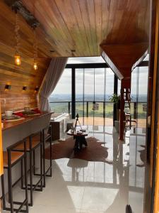 a living room with a table and a large window at Chalés Vista dei Monti 