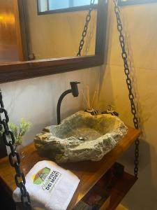 a bathroom with a rock sink on a table at Chalés Vista dei Monti 