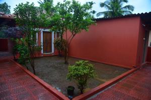 a red house with trees and a red wall at Panchavati Home Stay in Sringeri