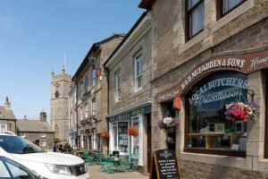 a street with buildings and a car parked in front of a store at Bright and Modern St Just 1 bedroom apartment in old Cornwall in St. Just