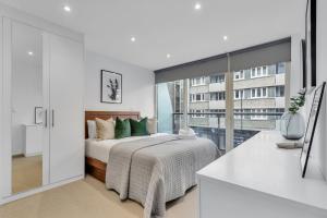 a white bedroom with a bed and a large window at Clerkenwell Serviced Apartment by MySquare in London