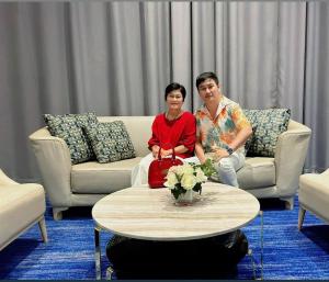 a man and woman sitting on a couch in a living room at โรงแรมบ้านมะลิ ฮิลล์ เรสซิเด้นท์ in Kaeng Khlo