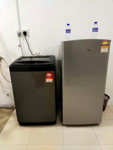 einen Kühlschrank neben in der Unterkunft Homestay Manitha in Seri Manjung