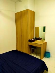 a bedroom with a bed and a desk with a mirror at Homestay Manitha in Seri Manjung