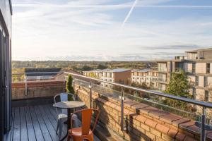 a balcony with a table and chairs on a building at Cotels at 7Zero1 Serviced Apartments - Modern Apartments, Superfast Broadband, Free Parking, Centrally Located in Milton Keynes