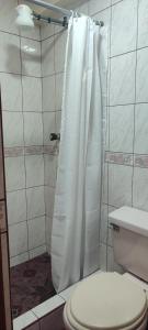 een douche met een wit douchegordijn in de badkamer bij Hostel Tupac Yupanqui House in Cuzco