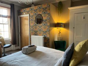 a bedroom with a bed and a wall with a mirror at Kelston Guest House in Weymouth