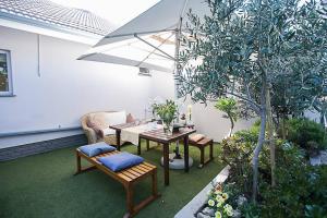 a patio with a table and chairs and an umbrella at Delightful db story loft with airconditioning in Hermanus