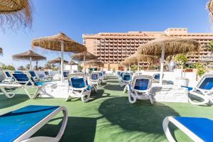 a group of chairs and umbrellas on a beach at Solana Fuengirola 40 in Fuengirola