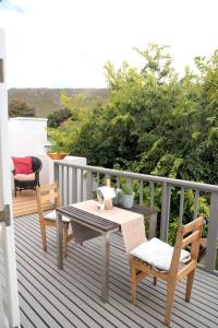 a patio with a table and chairs on a balcony at Delightful db story loft with airconditioning in Hermanus